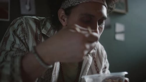 Un chico de la generación Z sostiene un tazón de plástico y come arroz con palillos