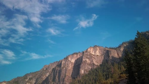 Panning shot along rocky granite ridge line to Yosemite Valley in the distance. 4K