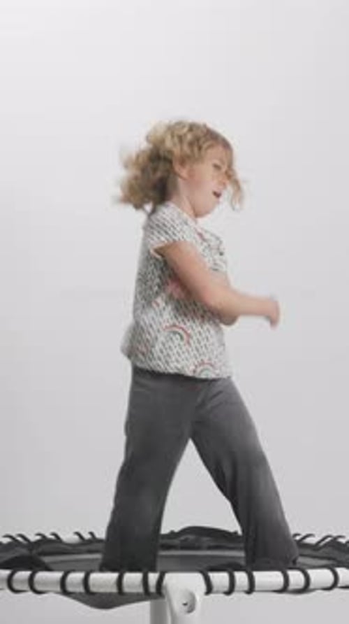 Joyful Child Bouncing and Dancing on a Trampoline