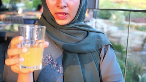 Women Drinking Orange Juice Sitting on Cafe