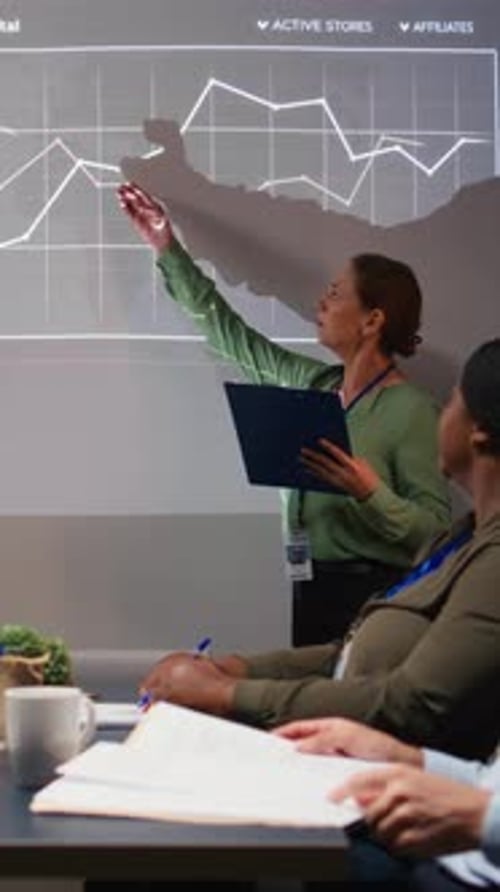 Vertical Video Diverse Business Associates Reviewing Performance Metrics Data