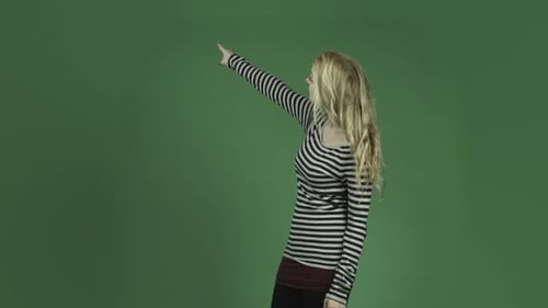 caucasian woman isolated on chroma green screen background pointing smiling