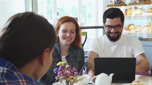 Cheerful Friends Savoring Breakfast Delights at a Cozy Coffee Shop