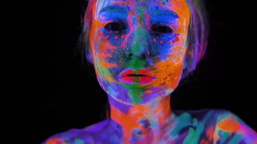 Portrait of a Model with Fluorescent Makeup Posing in UV Light with Colorful Makeup