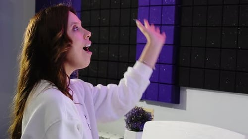 Enthusiastic Woman Singing Passionately in Recording Studio