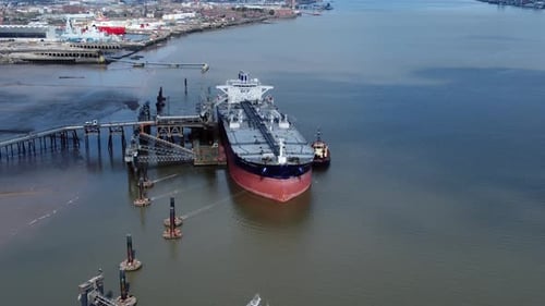 Crude oil tanker ship loading at refinery harbour terminal aerial reverse view