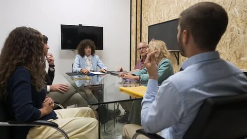 Businesspeople Brainstorming Over Project During Conference Meeting in Office