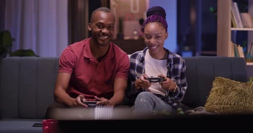 Smiling Couple Playing Video Games in Living Room
