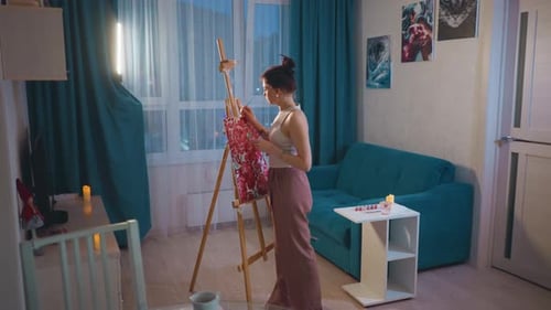 Woman with Bun Paints Floral Image in Apartment