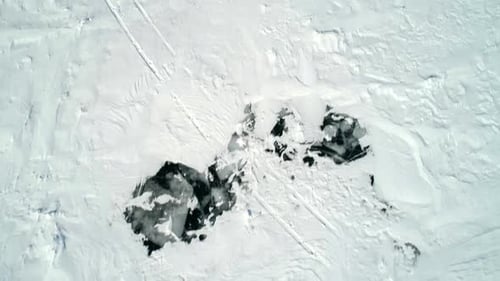 Aerial Over Snow Covered Cracked Ice of Frozen Baikal and Snowcapped Mountains Beautiful Winter