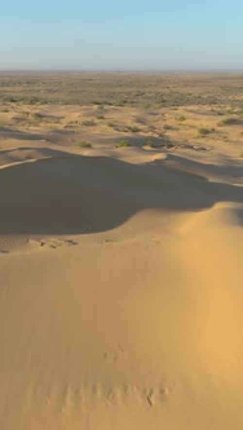 Drone Flying Smoothly at High Altitude Over Sand Dunes in Desert Aerial View Vertical Video