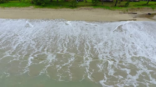 The camera captures the beauty of a tropical beach from above, slowly moving down to showcase the st