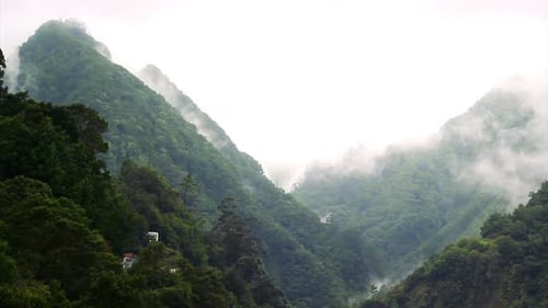 Aufnahmen von Wolken, die mit normaler Geschwindigkeit die Berge hinunter in ein Tal fallen.