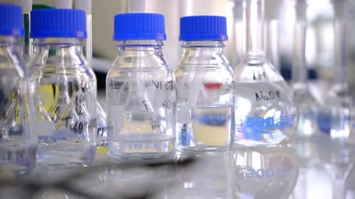 Bottles and Beakers Filled With Clear Liquid in Lab