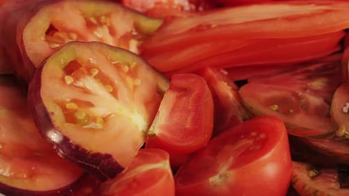 Schneiden Sie bunte Bio-Tomaten auf einem Schreibtisch aus Holz, mischen Sie den Hintergrund aus Tomaten, verschiedene Sorten in Scheiben