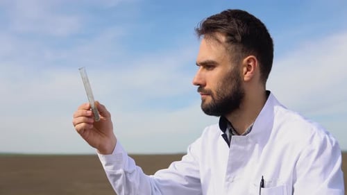 Scientist Studying Sample of Soil in Field Closeup