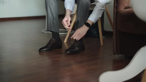 Man Tying Laces on Dress Shoes Indoors