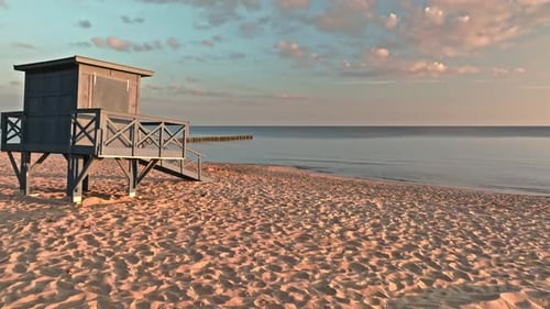 Lifeguard hut at sunrise on beach by Sea