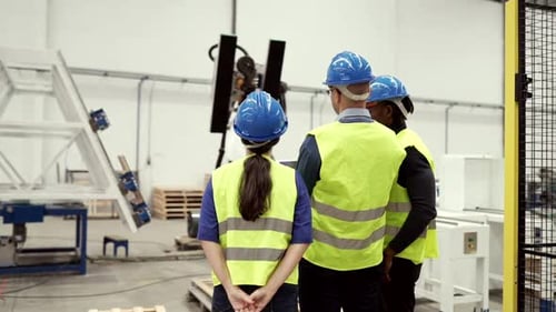 Engineers Observe Advanced Robotic Technology in Modern Factory