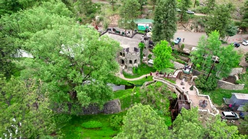 Aerial Drone Shot Of People Arriving At Castle Wedding Venue Surrounded By Beautiful Scenic Green Tr