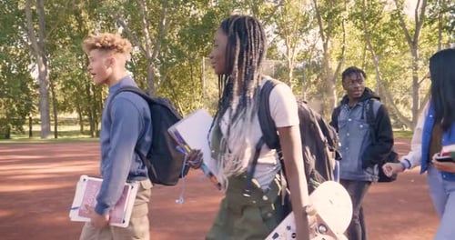 High School Students Walking and Talking in Park 1415 Years