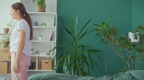 Woman Lies Back on Bed in Relaxing Room