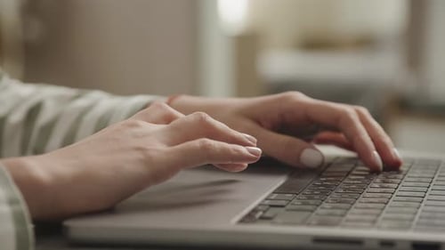 Hands Typing on Laptop Keyboard Indoors
