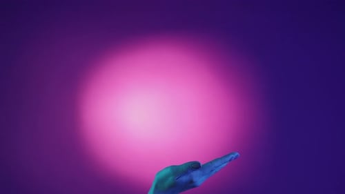 Hand Reaching Up in Purple Lit Space