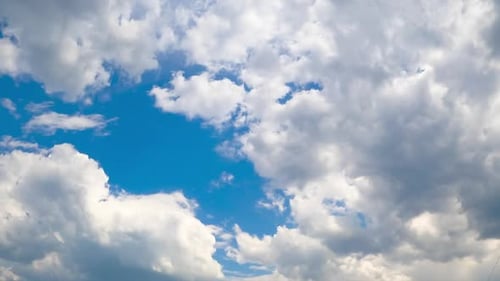 White cotton clouds soaring in the blue sky. Little clouds gathering into a big cloudscape.