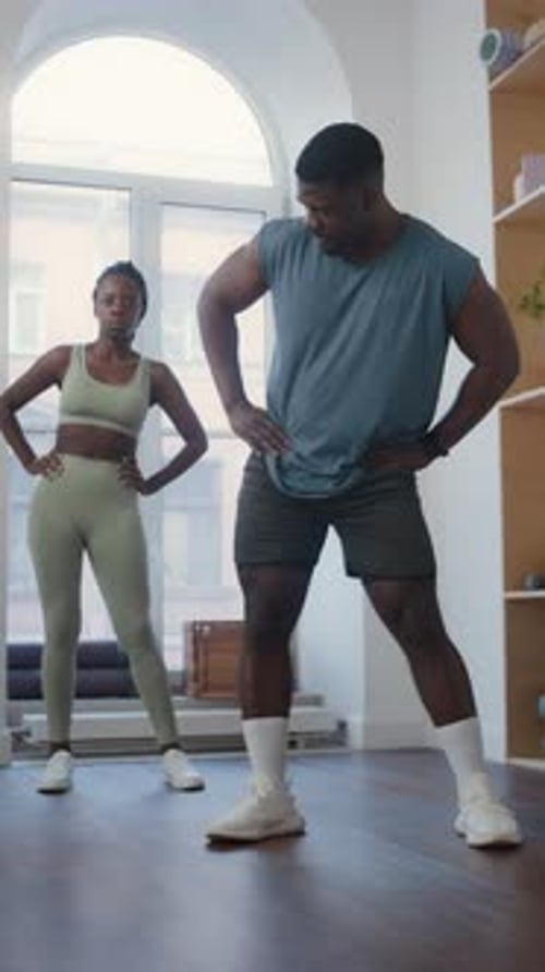Fitness Instructor and Woman Doing Hip Circles in Gym