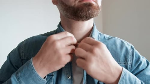 Man Fastening Buttons on Denim Shirt Close Up