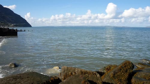 Relaxing blue ocean stone pebble beach coastline island holiday scene