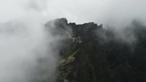 Aerial video between clouds from the top of the Pico Ruivo viewpoint, Madeira, Portugal.