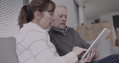 Senior Man and Woman Using a Tablet Device Indoors