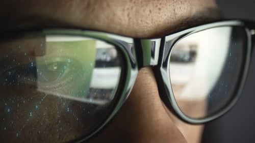 Un Code binaire composé de zéros et de uns se reflète sur les lunettes du visage d'un homme L'idée d'un numérique