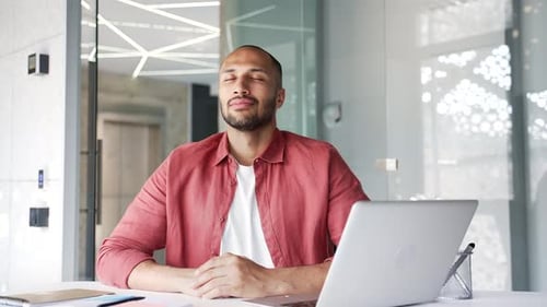 Businessman relaxing with his eyes closed sitting at a workplace in business office. Calm happy work
