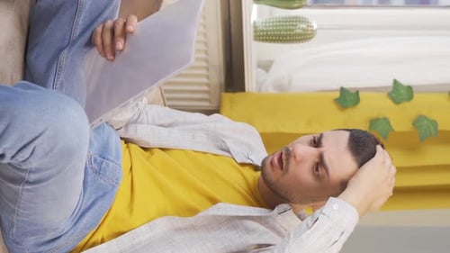 Young Adult Sitting on Couch with Document
