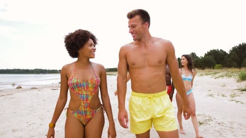 Friends walking on the beach together on summer day