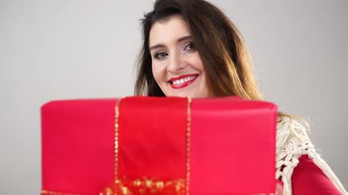 Smiling Woman Holding a Festive Christmas Gift
