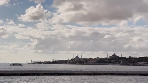 Ferries, boats, sailboats, birds, breakwater, pier, waves in the sea in cloudy weather in autumn