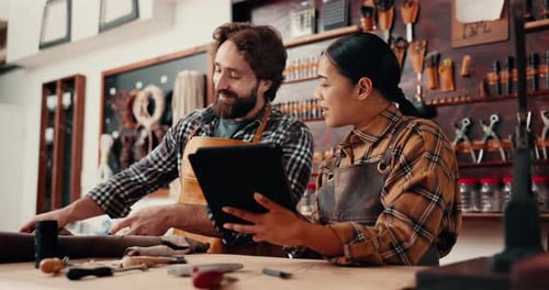 Leather factory, man and woman with tablet in discussion and tools for manufacturing of unique
