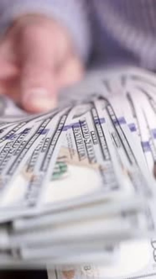 Close Up of Hands Counting Stack of Dollars