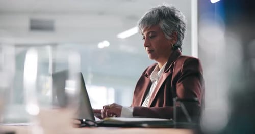 Mature woman, laptop and typing at office with report, review and deadline for project at media