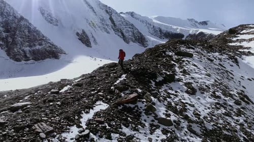 Lone Climber Trekking Across Rocky Mountain Ridge