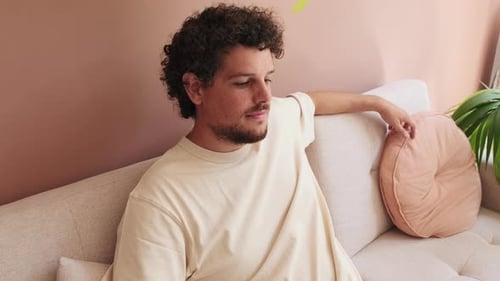 Man Relaxing on Sofa in Modern Living Room