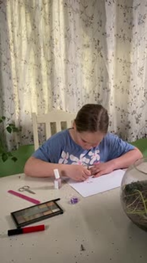 Child Puts Glitter on Nails at Table
