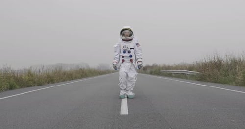 An astronaut just landed from space, on the new planet, walks in the middle of a road to explore t