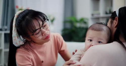 Loving Women and Infant Relaxing Indoors at Home