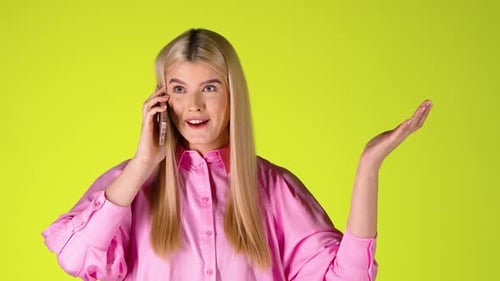Pretty Blonde Woman Talking On Phone Smiling and In Good Mood, Colorful Studio Shot