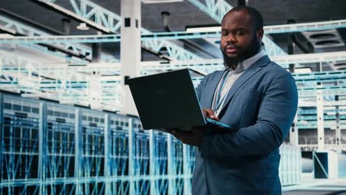 Happy Programmer in Server Hub Using Laptop to Do Maintenance Tasks